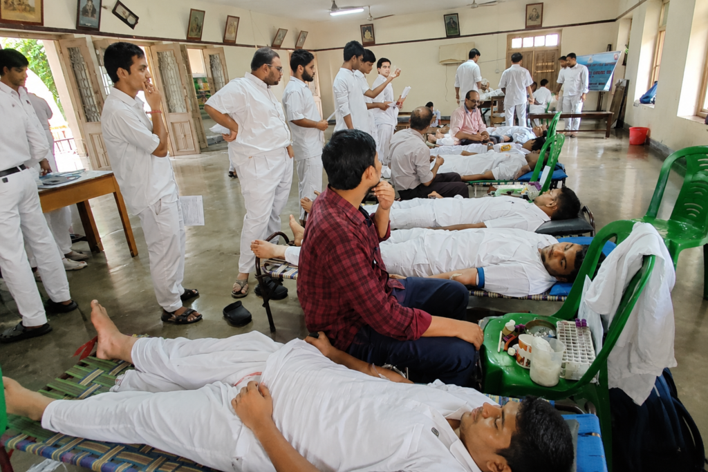রক্তদান কর্মসূচিতে অংশগ্রহণকারী ছাত্রছাত্রীদের ছবি, যেখানে স্বেচ্ছায় রক্তদাতারা রক্তদান করছেন এবং স্বেচ্ছাসেবীরা তাঁদের সহযোগিতা করছেন।